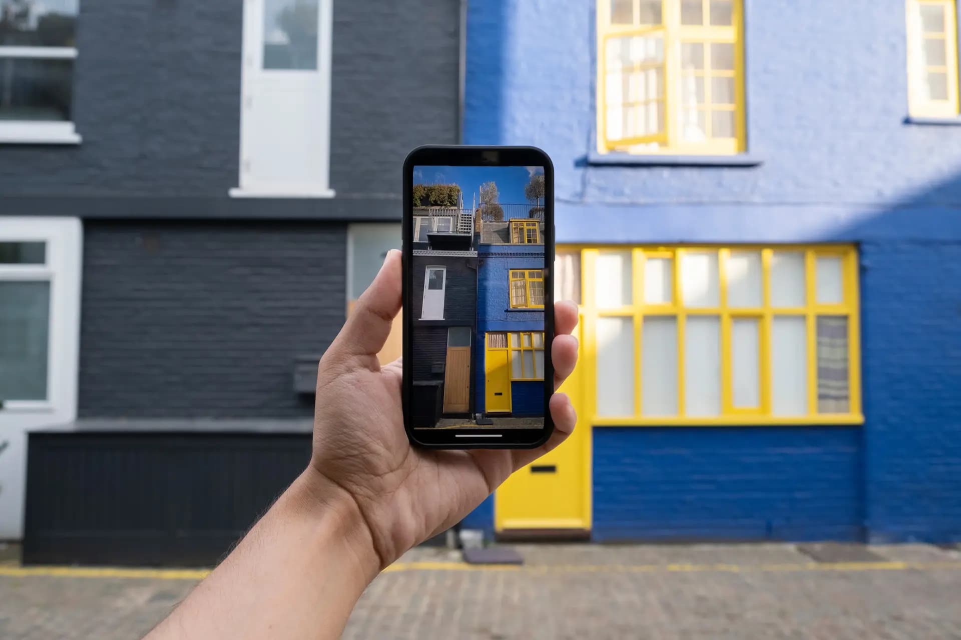 afbeelding van een smartphone die een foto van een huis neemt